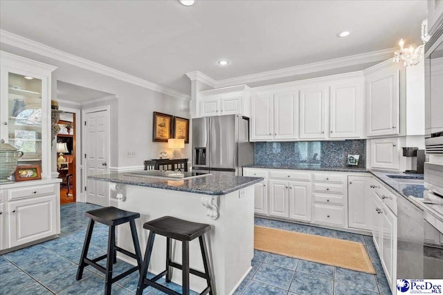 kitchen with a breakfast bar area, stainless steel fridge with ice dispenser, white cabinets, backsplash, and a center island