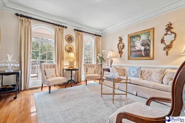 living room with visible vents, light wood finished floors, and ornamental molding