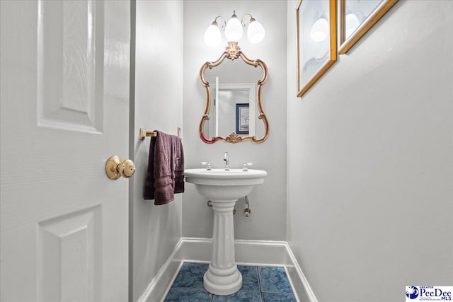 bathroom featuring a sink, baseboards, and tile patterned flooring