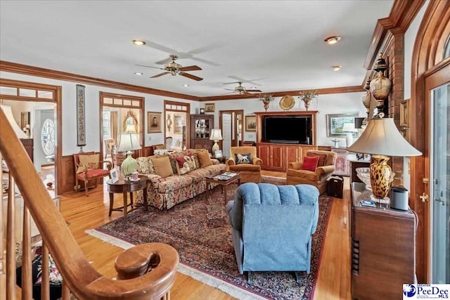 living room with stairway, a wainscoted wall, recessed lighting, ornamental molding, and light wood-style floors