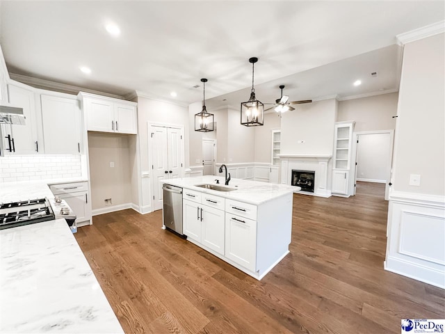 kitchen with stainless steel dishwasher, sink, white cabinetry, and light stone counters