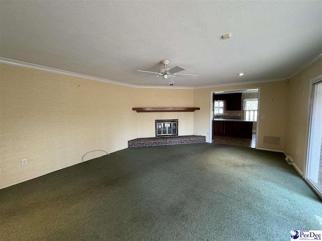 unfurnished living room featuring ceiling fan, crown molding, a textured ceiling, and carpet