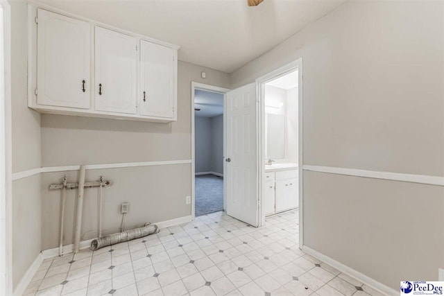 clothes washing area featuring cabinets, sink, and washer hookup