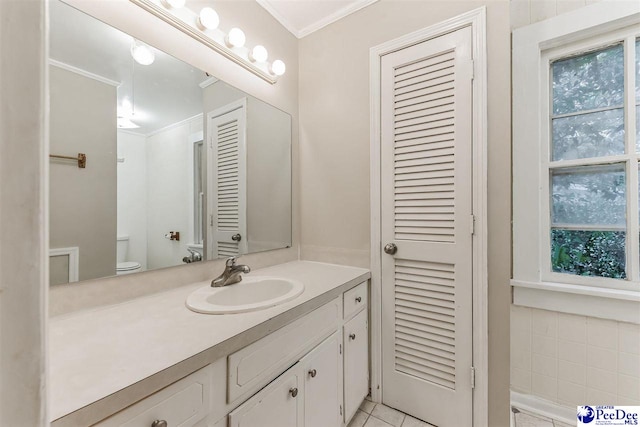 bathroom with crown molding, vanity, toilet, and tile patterned flooring