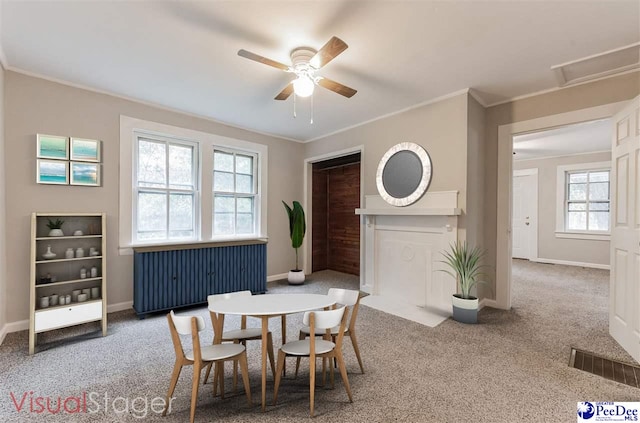 carpeted dining area featuring ornamental molding and ceiling fan