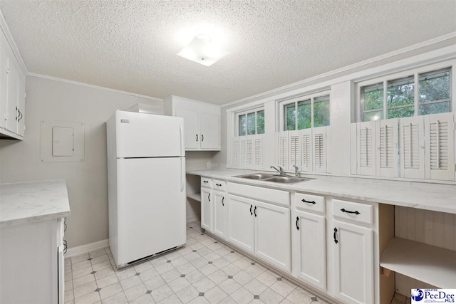 kitchen featuring sink, white cabinetry, a textured ceiling, ornamental molding, and white fridge