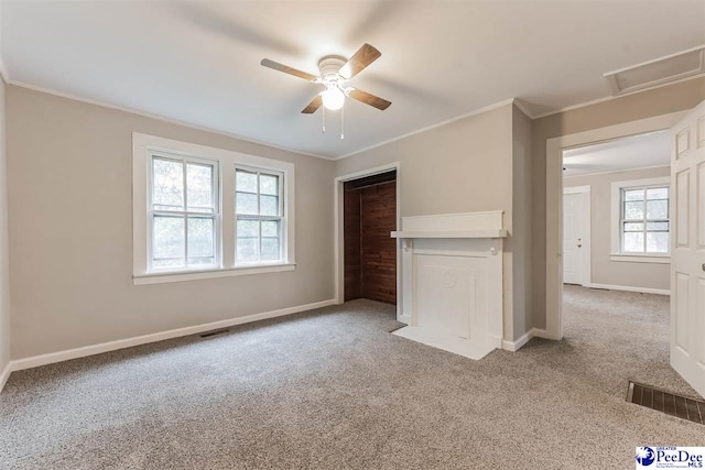 unfurnished bedroom featuring ceiling fan, ornamental molding, carpet flooring, and a closet