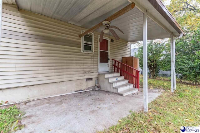 view of exterior entry featuring ceiling fan and a patio