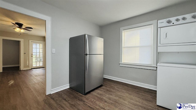 kitchen featuring stainless steel fridge, dark hardwood / wood-style floors, ceiling fan, and stacked washing maching and dryer