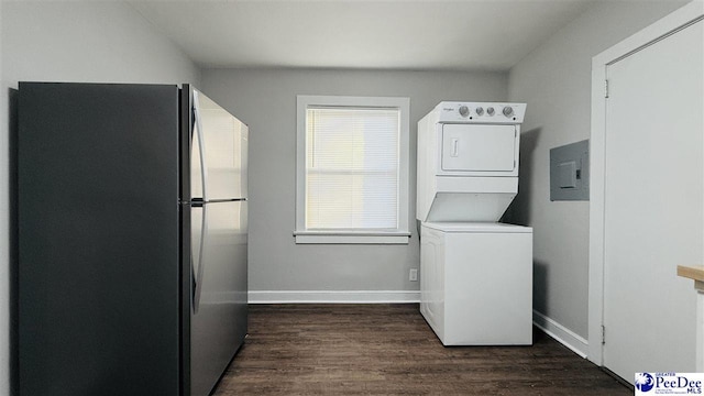 laundry area featuring stacked washer and clothes dryer, dark hardwood / wood-style floors, and electric panel