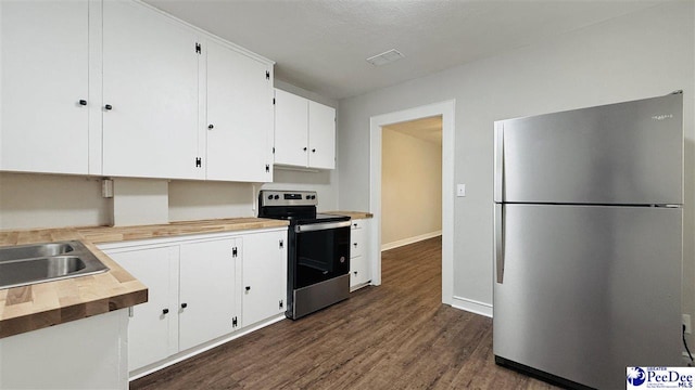 kitchen featuring appliances with stainless steel finishes, dark hardwood / wood-style floors, butcher block countertops, white cabinetry, and sink