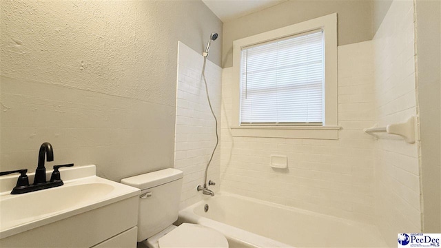 full bathroom with vanity, tiled shower / bath combo, and toilet