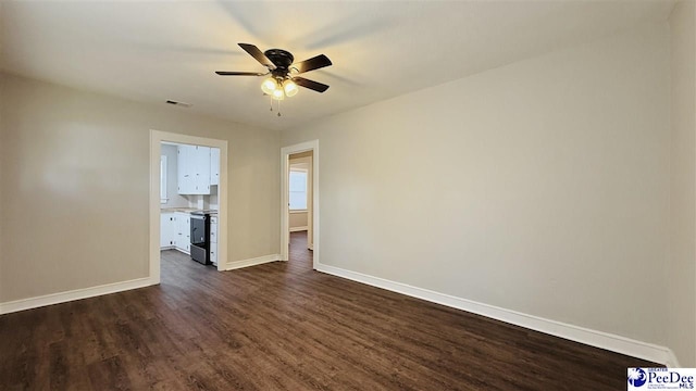 spare room with dark hardwood / wood-style floors and ceiling fan