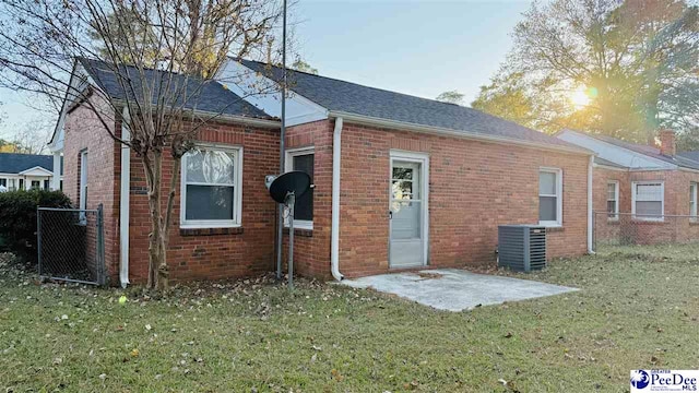 rear view of house featuring a patio, a yard, and central air condition unit