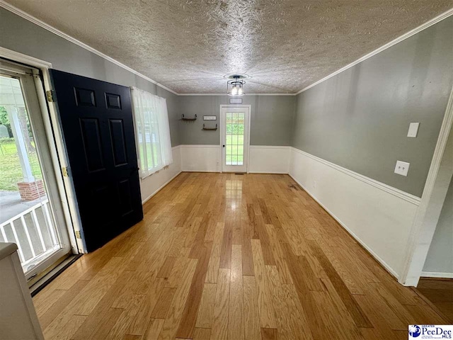 188 Chatham Trace Cir, Cheraw, SC 29520 - foyer featuring light wood finished floors, a textured ceiling, a wainscoted wall, and crown molding