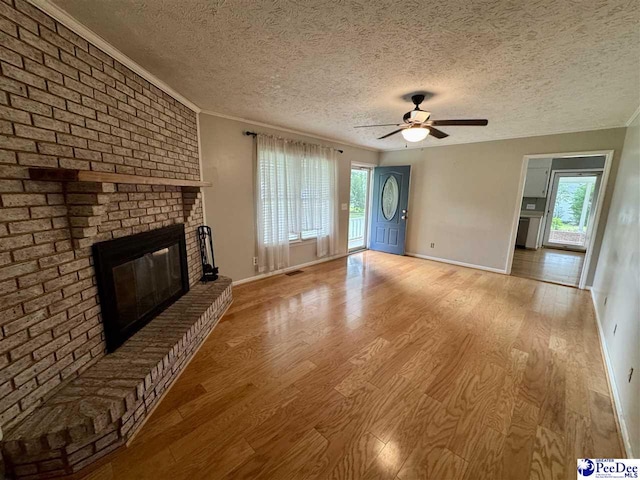 188 Chatham Trace Cir, Cheraw, SC 29520 - unfurnished living room with wood finished floors, plenty of natural light, a ceiling fan, a brick fireplace, and a textured ceiling