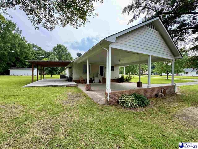 188 Chatham Trace Cir, Cheraw, SC 29520 - back of house featuring a lawn, a patio area, and a carport