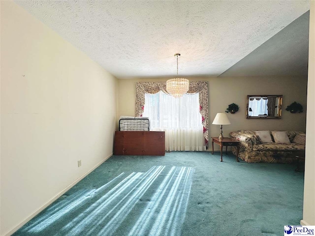 unfurnished room featuring a textured ceiling, carpet floors, and a chandelier