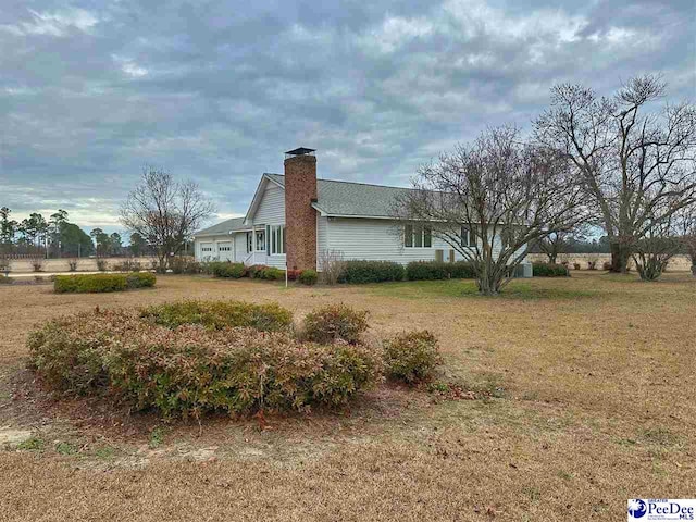 view of side of home with a yard