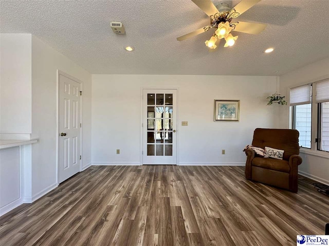 unfurnished room featuring ceiling fan, dark hardwood / wood-style floors, and a textured ceiling