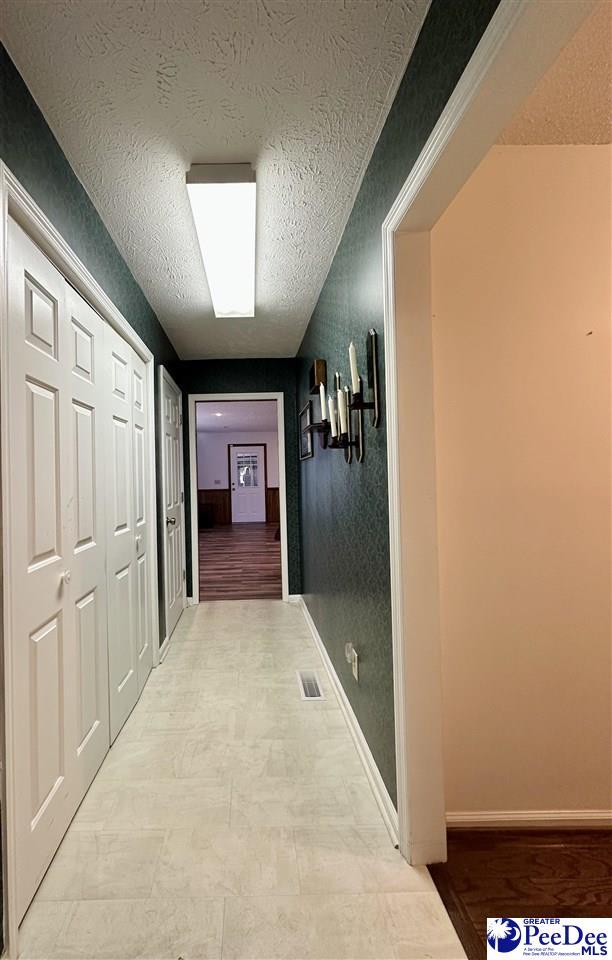 hall featuring a textured ceiling