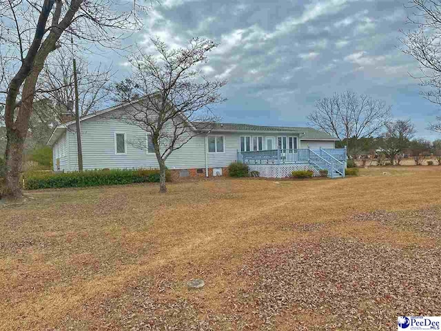 view of front of home featuring a wooden deck and a front yard