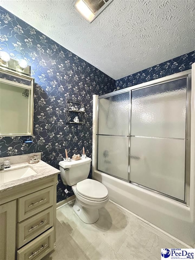 full bathroom featuring enclosed tub / shower combo, vanity, a textured ceiling, and toilet