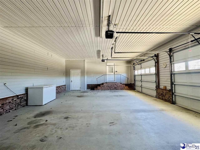 garage with a garage door opener and refrigerator