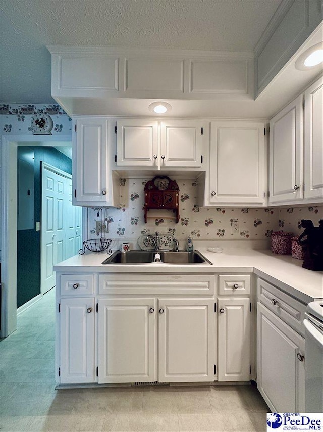 kitchen featuring sink, white cabinets, light tile patterned floors, electric panel, and a textured ceiling