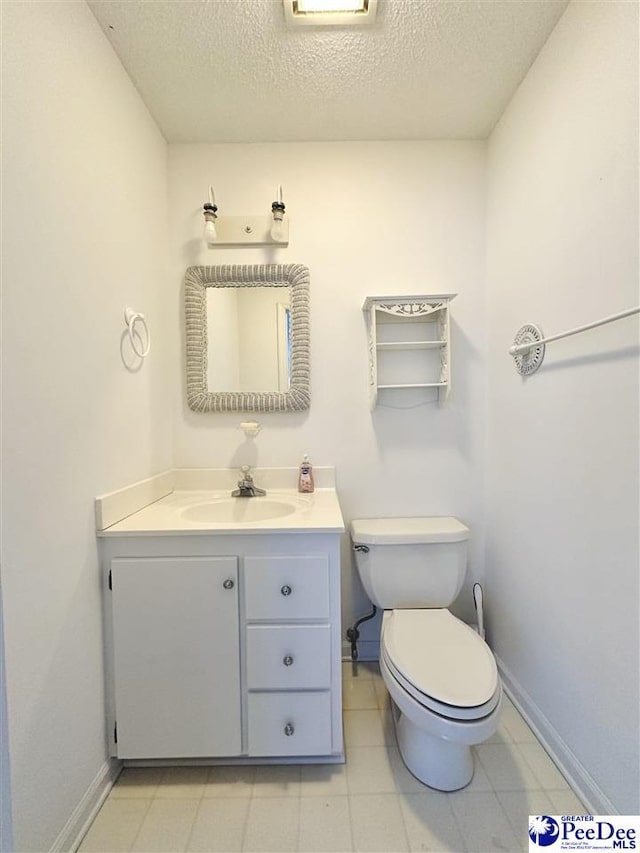 bathroom with vanity, toilet, and a textured ceiling