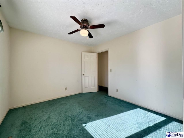 empty room with ceiling fan, a textured ceiling, and dark colored carpet