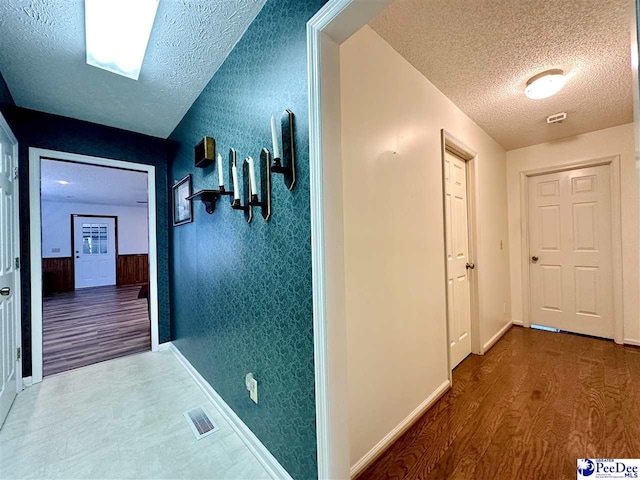 hall featuring hardwood / wood-style flooring and a textured ceiling