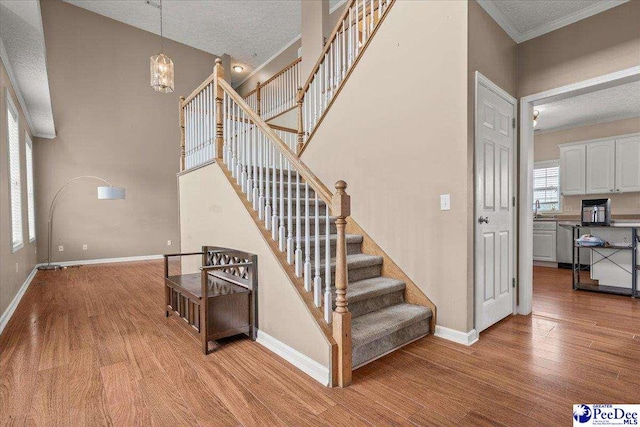 2770 Gray Dr, Darlington, SC 29532 - stairway featuring wood finished floors, a textured ceiling, and a chandelier