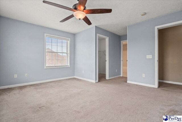 2770 Gray Dr, Darlington, SC 29532 - unfurnished bedroom featuring carpet floors, a spacious closet, a textured ceiling, a ceiling fan, and a closet