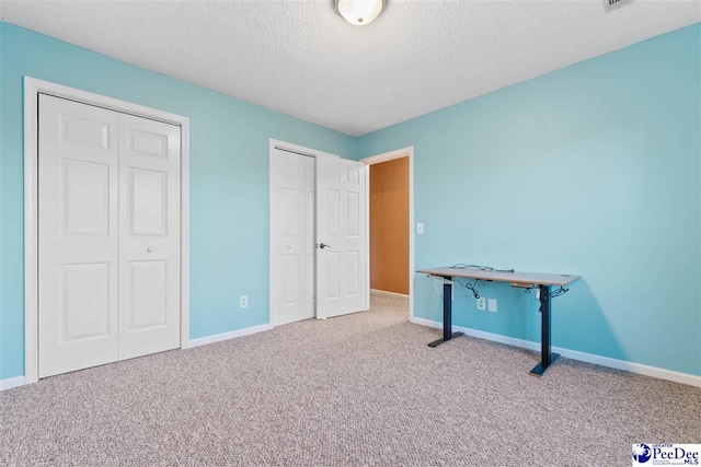 unfurnished bedroom with carpet floors and a textured ceiling