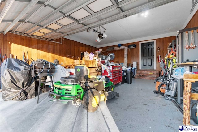 garage with a garage door opener and wooden walls