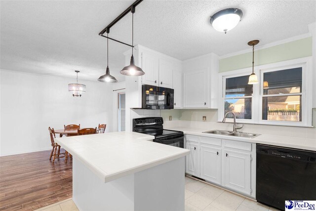 kitchen featuring hanging light fixtures, sink, white cabinets, and black appliances