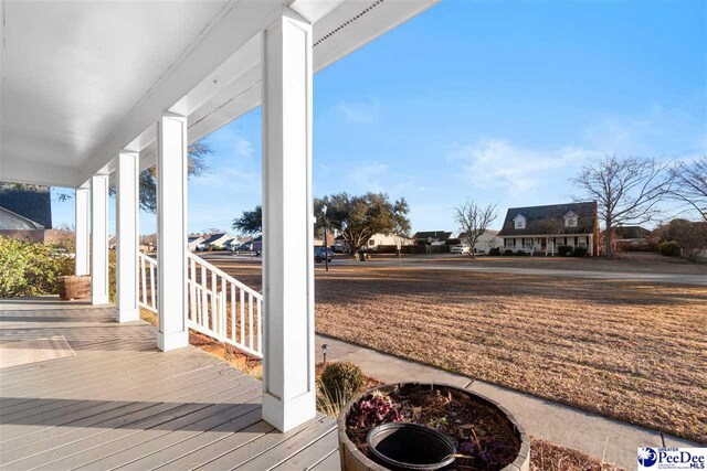 wooden terrace featuring an outdoor fire pit and a porch