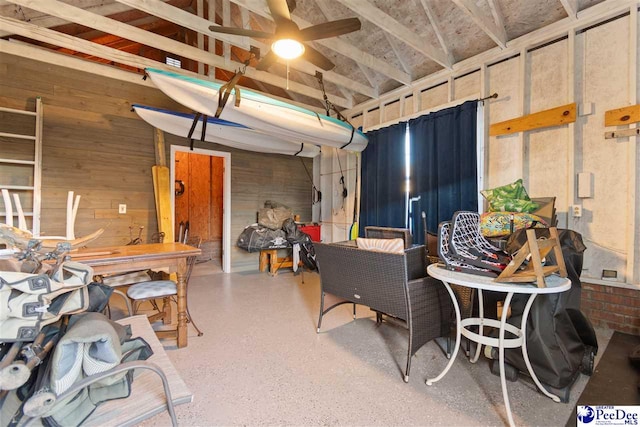 interior space featuring wooden walls and ceiling fan