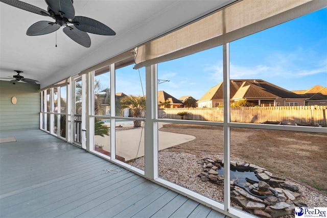 unfurnished sunroom featuring ceiling fan