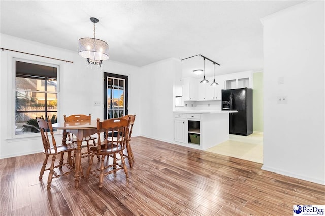 dining room with an inviting chandelier and light hardwood / wood-style flooring