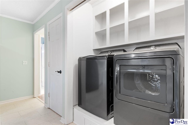 clothes washing area featuring crown molding and washer and dryer