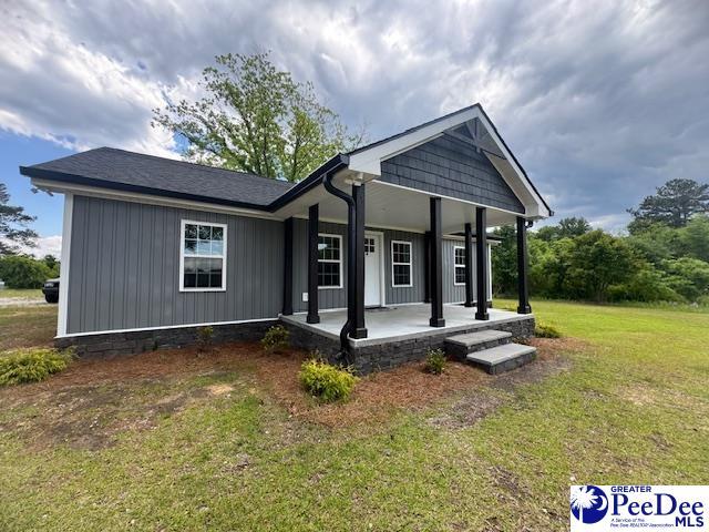 view of front of home with a front yard and a porch