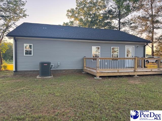 back of house with central AC unit, a yard, and a wooden deck