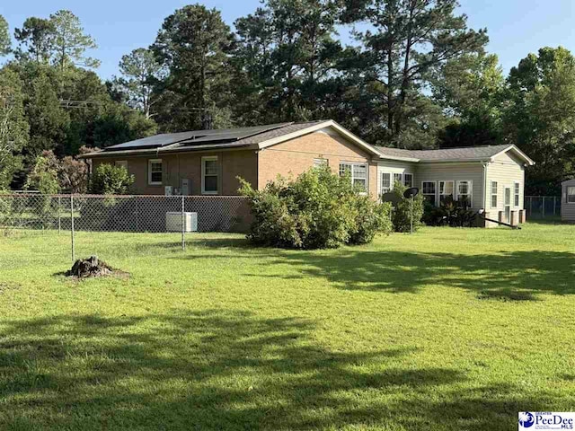1801 E Howe Springs Rd, Florence, SC 29505 - rear view of property featuring roof mounted solar panels and view of scattered trees