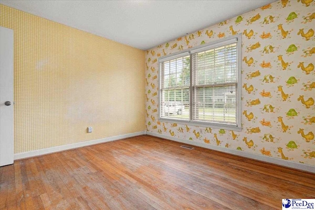 1216 Arrowood Dr, Florence, SC 29501 - unfurnished room with wallpapered walls, wood finished floors, and baseboards