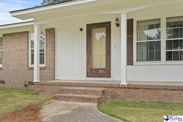 1216 Arrowood Dr, Florence, SC 29501 - view of exterior entry featuring crawl space, covered porch, and brick siding