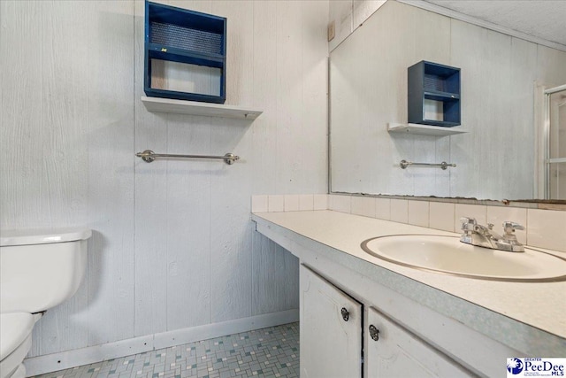 1216 Arrowood Dr, Florence, SC 29501 - bathroom with toilet, vanity, wood walls, and baseboards