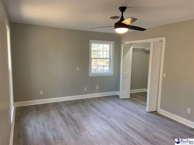 unfurnished bedroom featuring ceiling fan, light wood-type flooring, and a closet