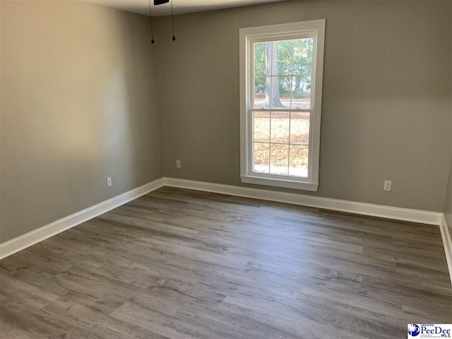 unfurnished room with hardwood / wood-style floors and ceiling fan